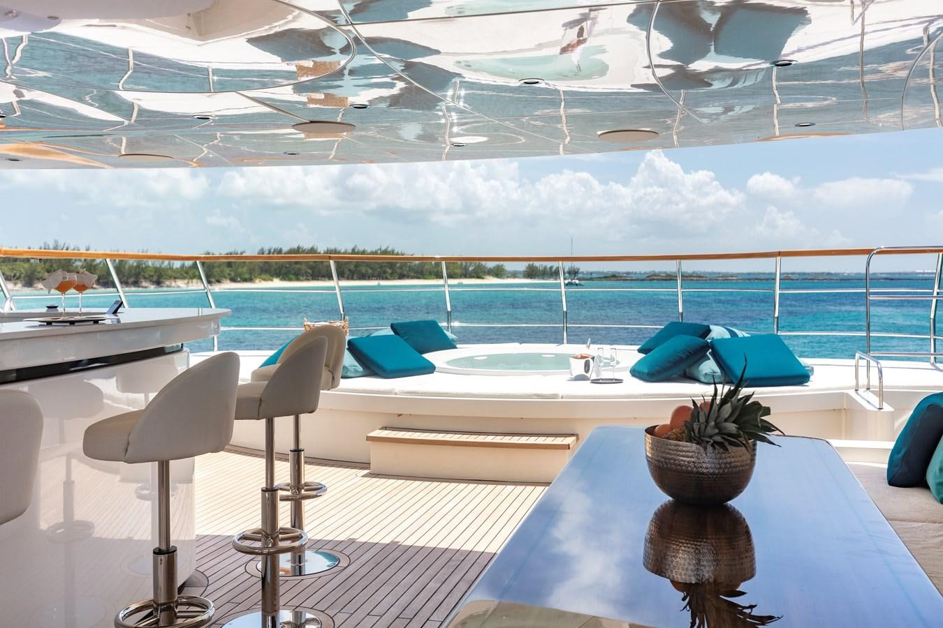 a table with chairs and a pool aboard MYSTIC Yacht for Sale