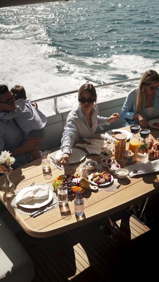 a group of people sitting at a table with food and drinks on it aboard NEW EDGE Yacht for Sale