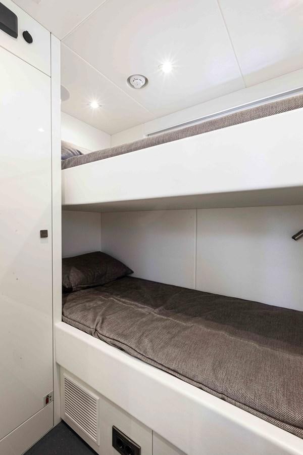 a bed with a white wall aboard NEW EDGE Yacht for Sale