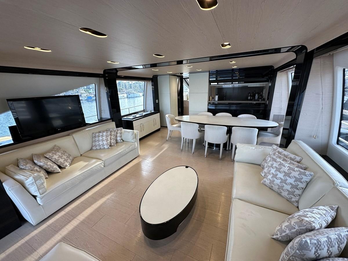 a living room with a large table and couches aboard SLINGSHOT Yacht for Sale