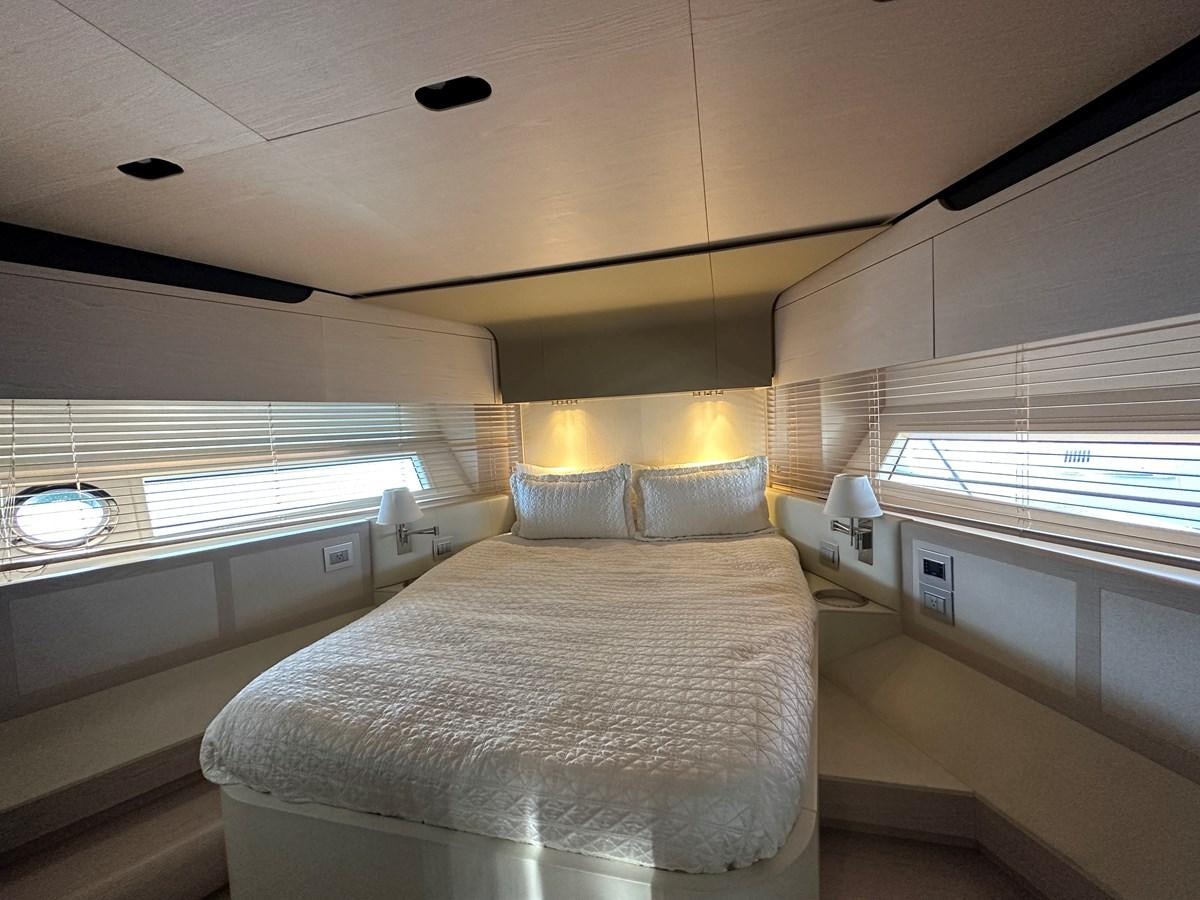 a bedroom with a bed and a window aboard SLINGSHOT Yacht for Sale
