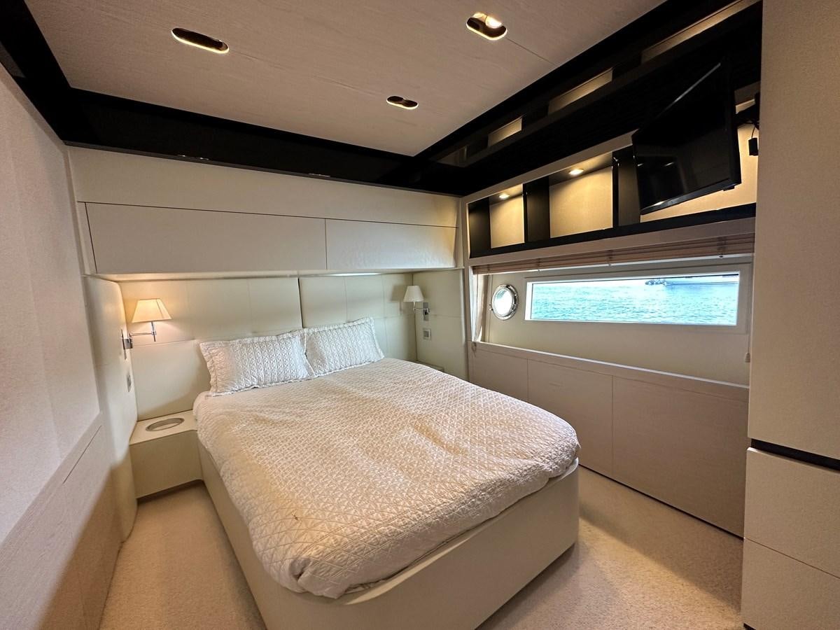 a bedroom with a bed and a window aboard SLINGSHOT Yacht for Sale