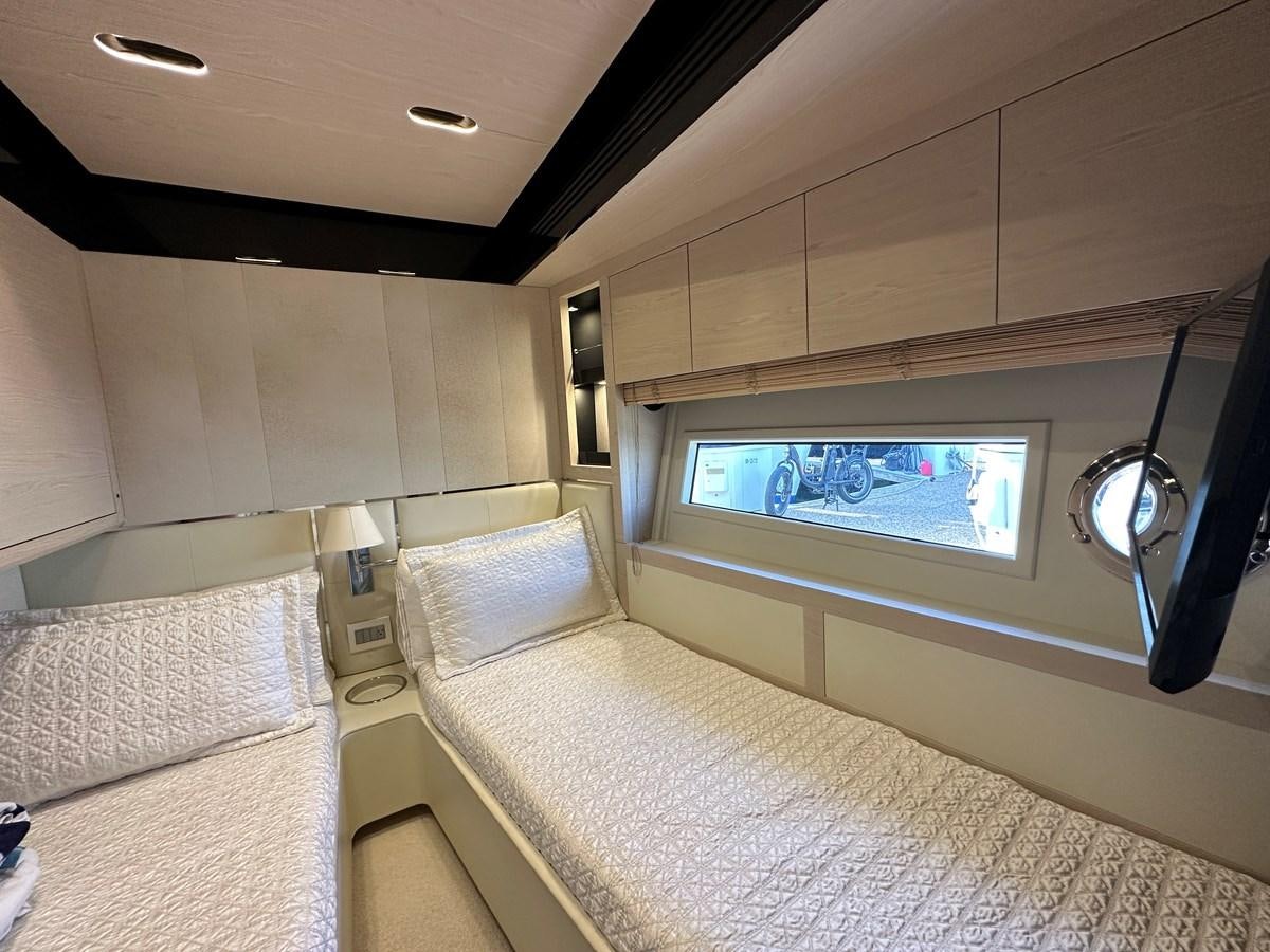 a room with a bed and a television aboard SLINGSHOT Yacht for Sale