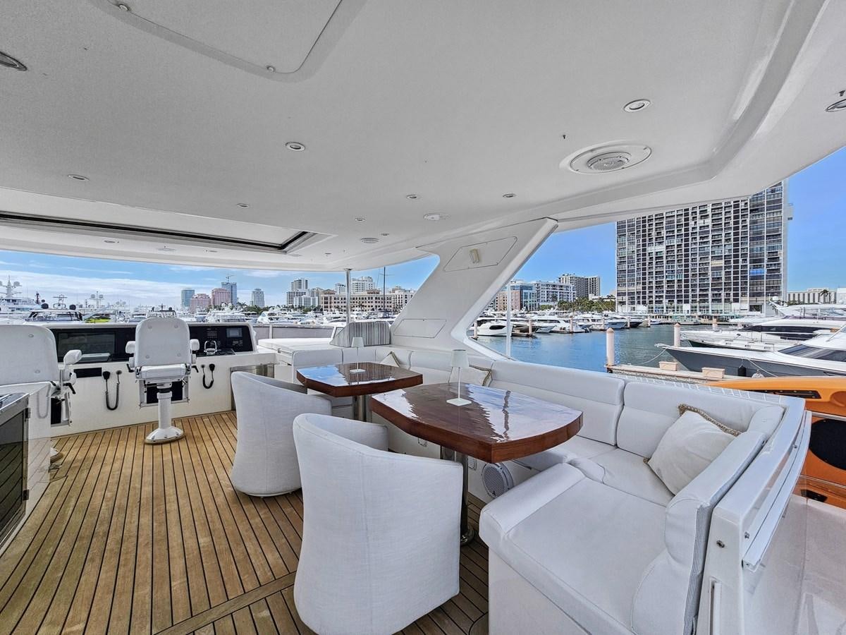 a room with a table chairs and a view of the water aboard O A Yacht for Sale