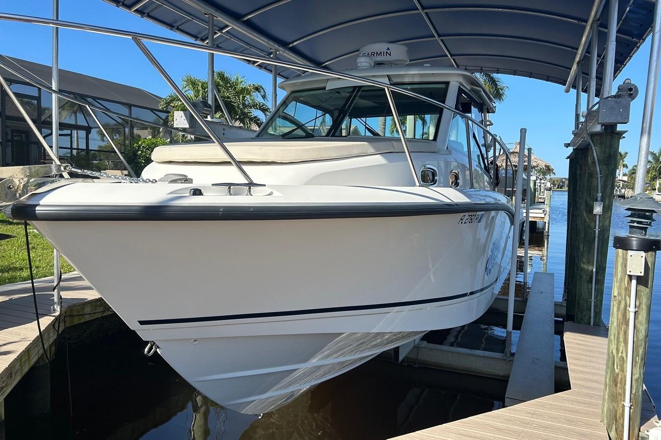 a white boat on a dock aboard B Yacht for Sale