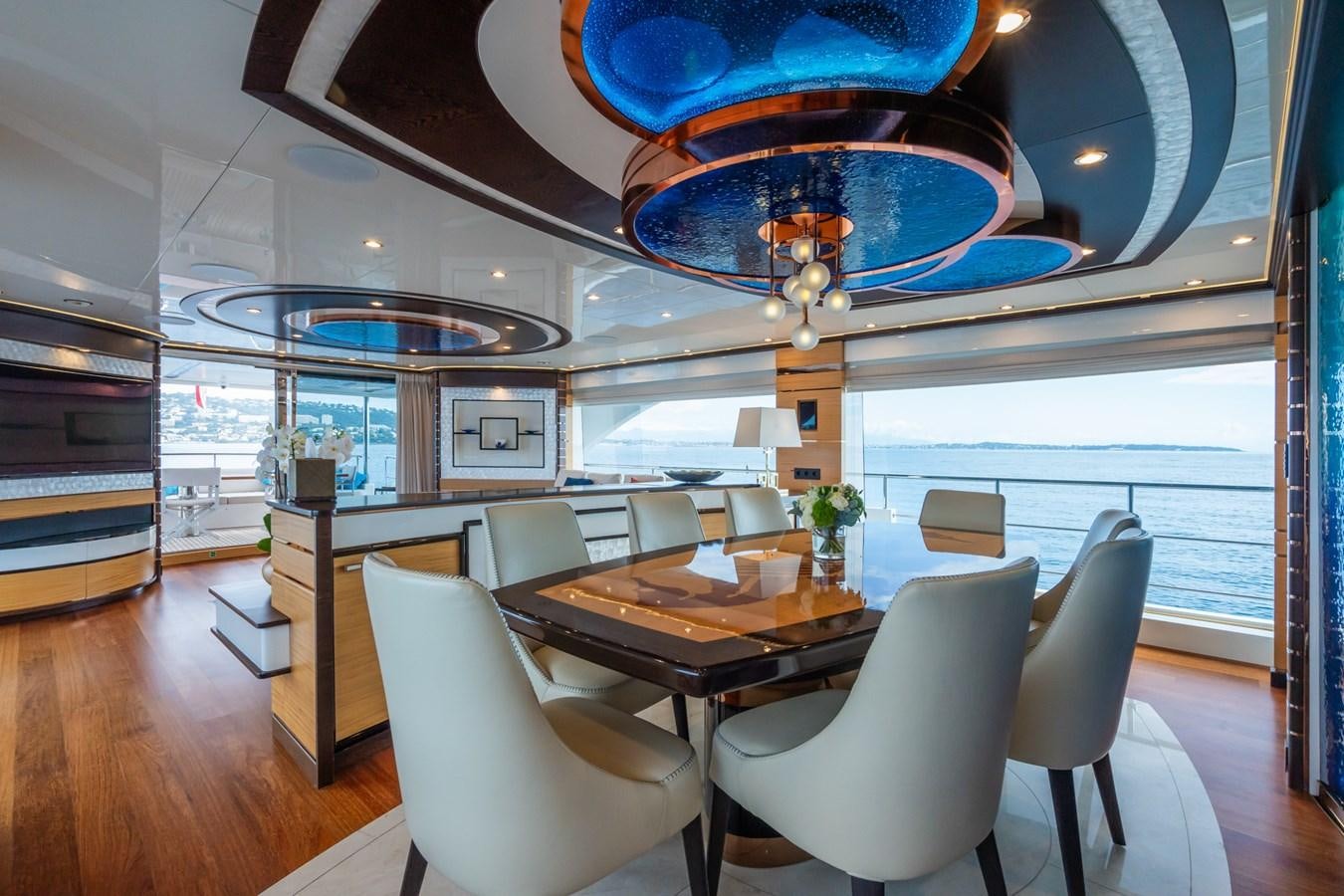 a room with a table chairs and a large window aboard MY PARADIS Yacht for Sale