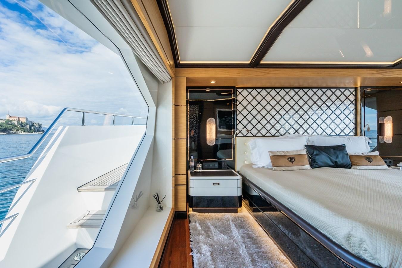 a room with a bed and a large window aboard MY PARADIS Yacht for Sale
