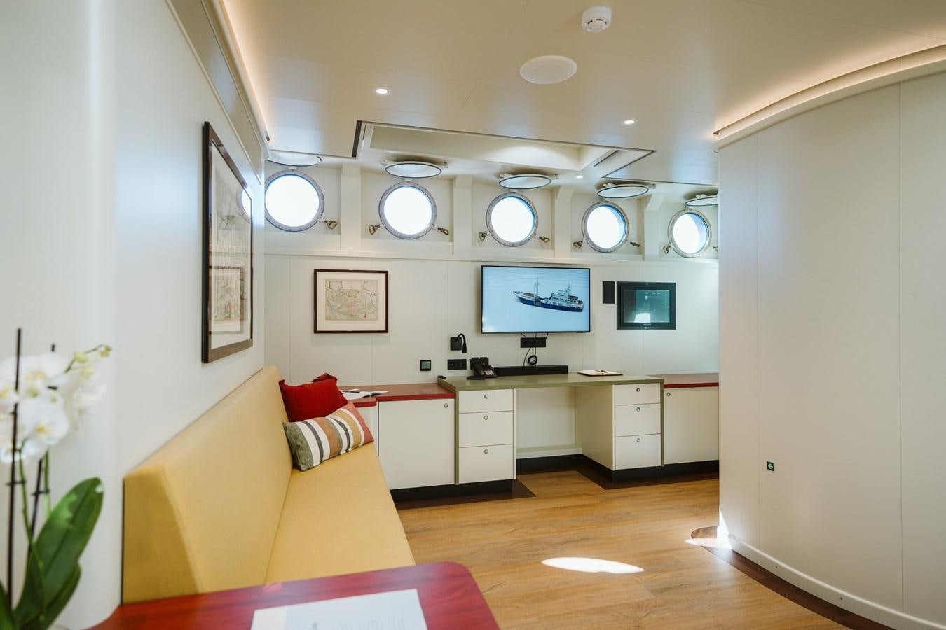 a room with a couch and a tv on the wall aboard SCINTILLA MARIS Yacht for Sale