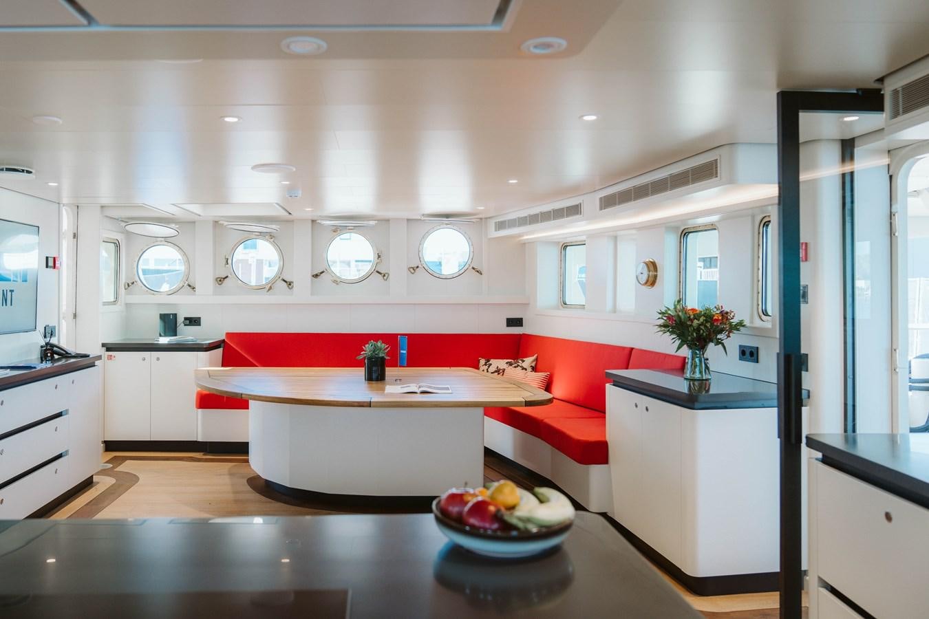 a kitchen with a red couch aboard SCINTILLA MARIS Yacht for Sale