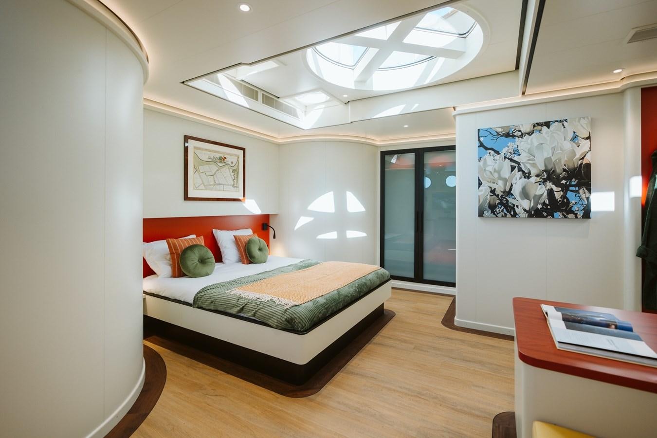 a bedroom with a bed and a desk aboard SCINTILLA MARIS Yacht for Sale