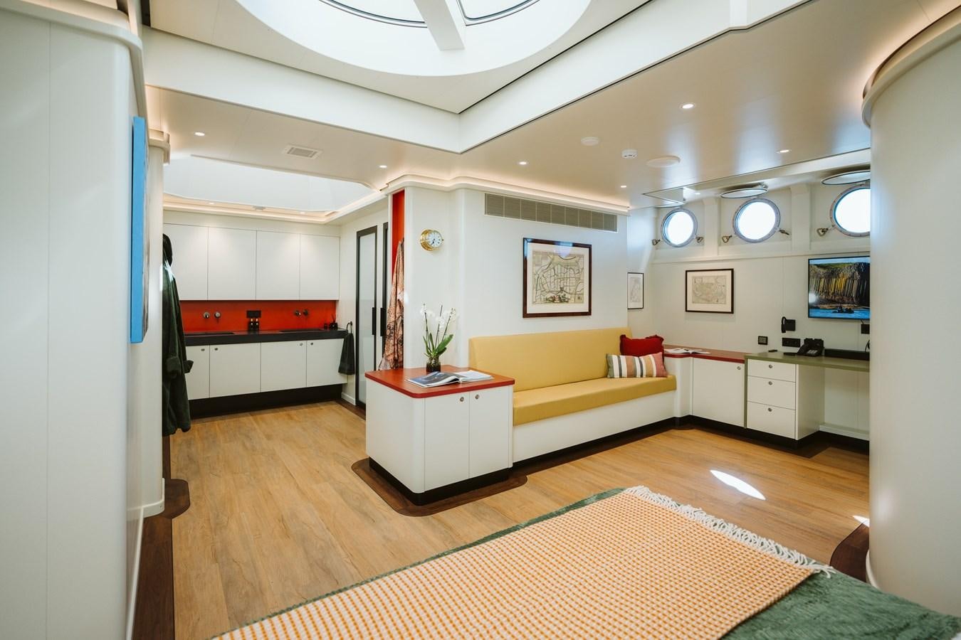 a living room with a yellow couch aboard SCINTILLA MARIS Yacht for Sale