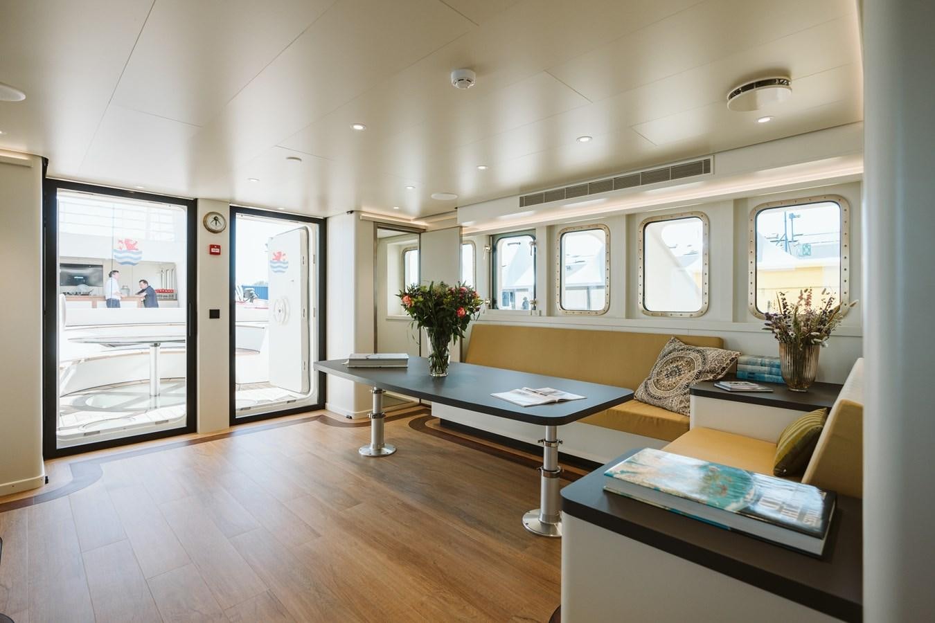 a living room with a table and couches aboard SCINTILLA MARIS Yacht for Sale