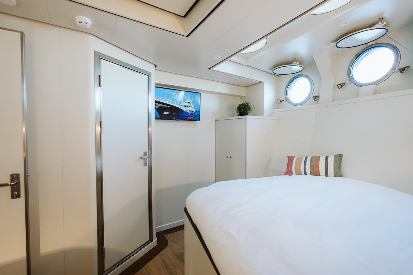 a bedroom with a bed and a television aboard SCINTILLA MARIS Yacht for Sale
