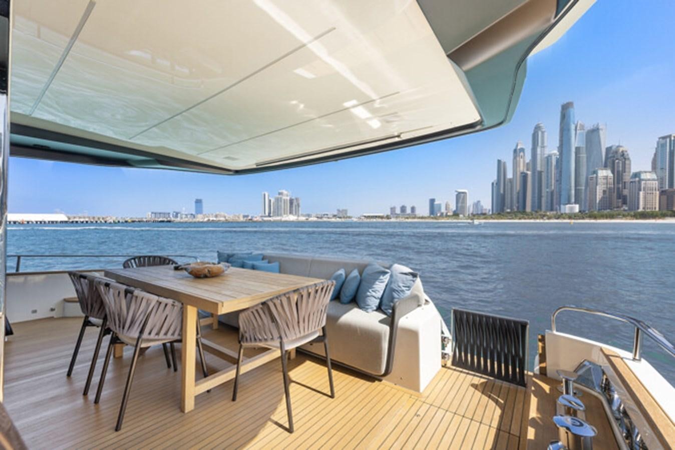 a table and chairs on a deck overlooking a city aboard MOSHE Yacht for Sale