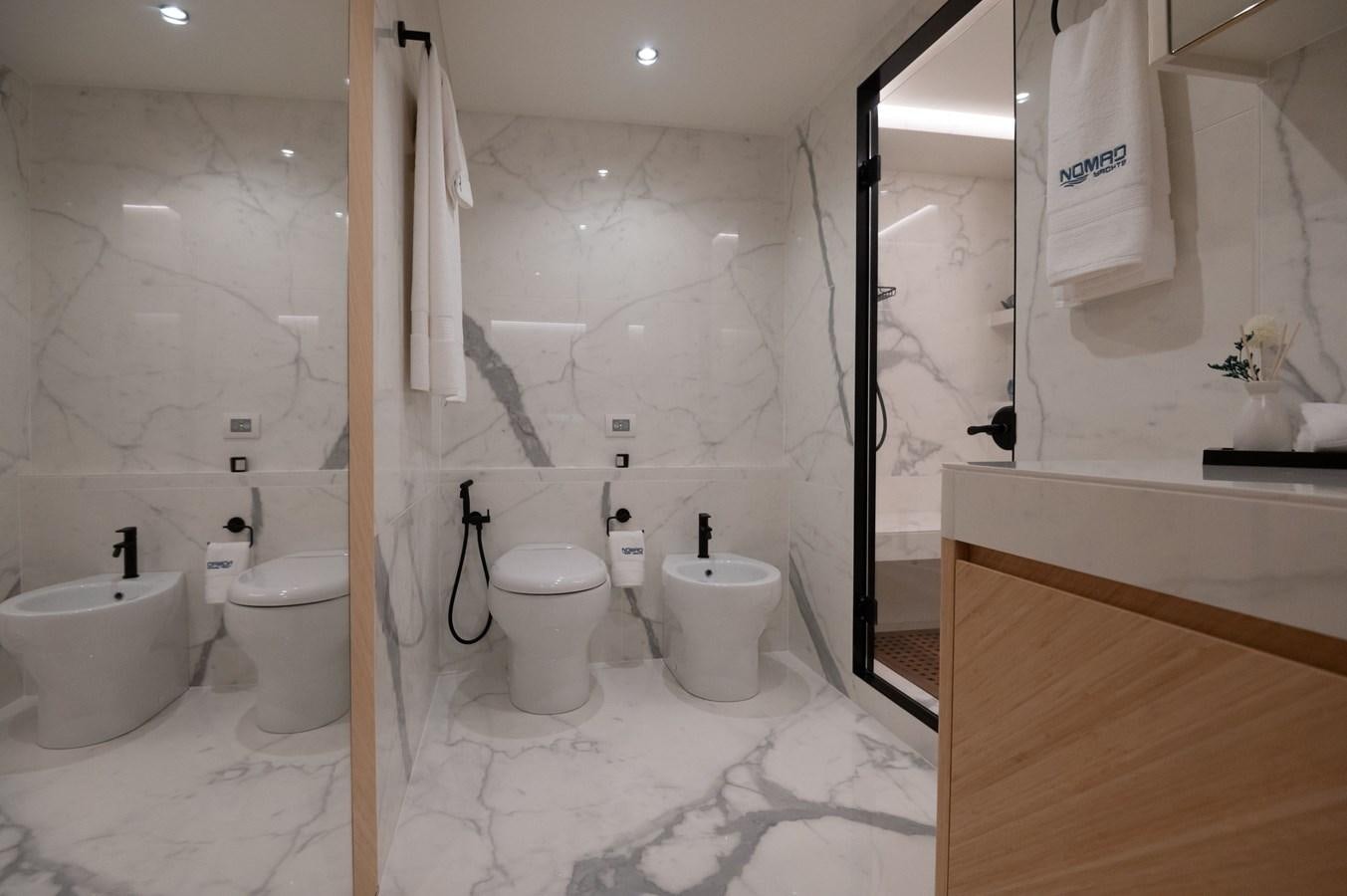 a bathroom with a toilet and sink aboard #5 NOMAD 101 Yacht for Sale