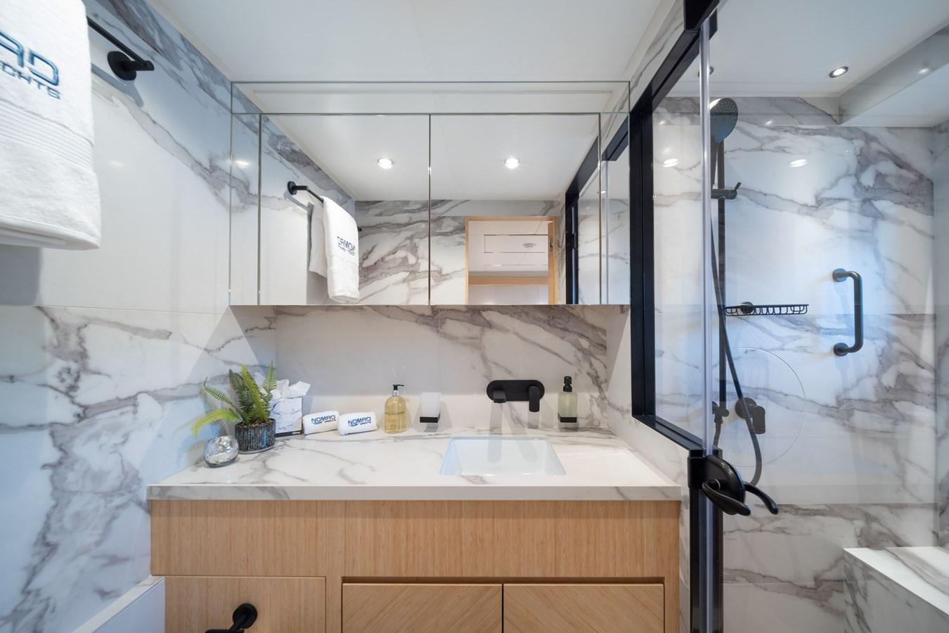 a bathroom with a sink and a shower aboard #5 NOMAD 101 Yacht for Sale