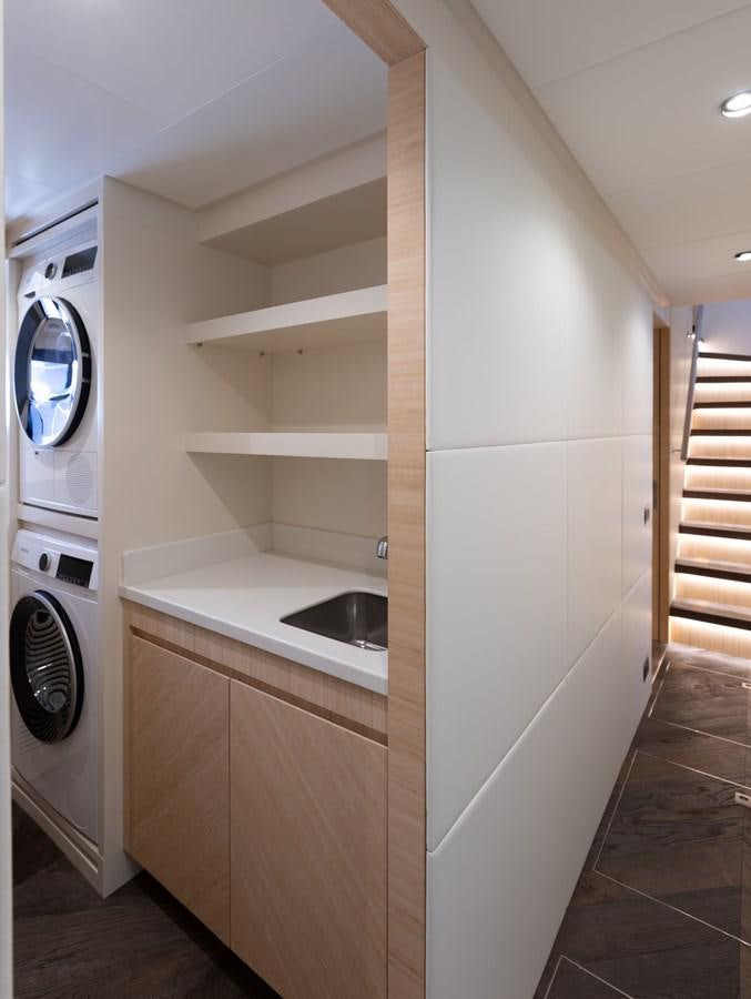 a white kitchen with a white wall aboard #5 NOMAD 101 Yacht for Sale