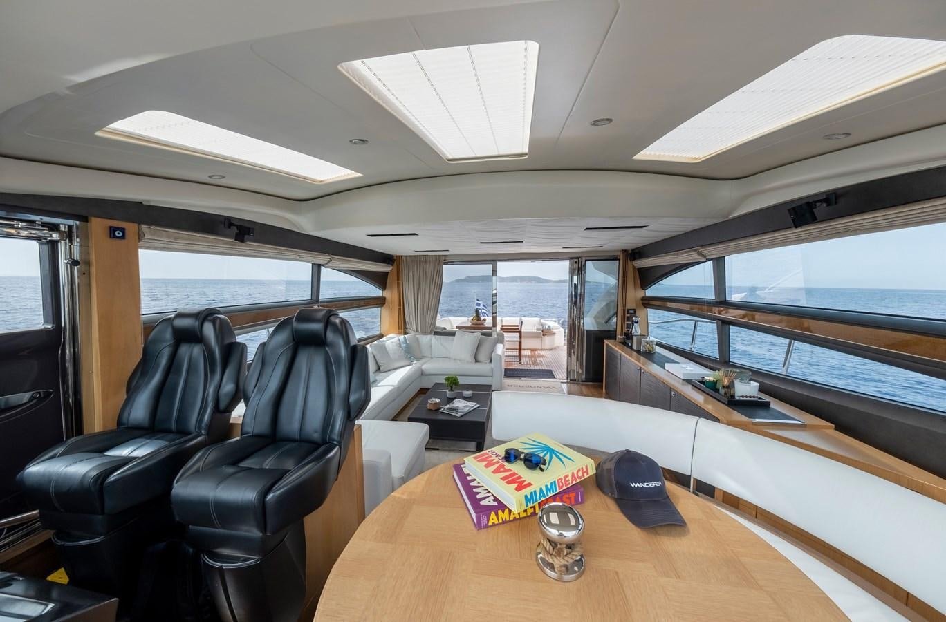 inside of a vehicle with a table and chairs and a book on the table aboard WANDERER Yacht for Sale