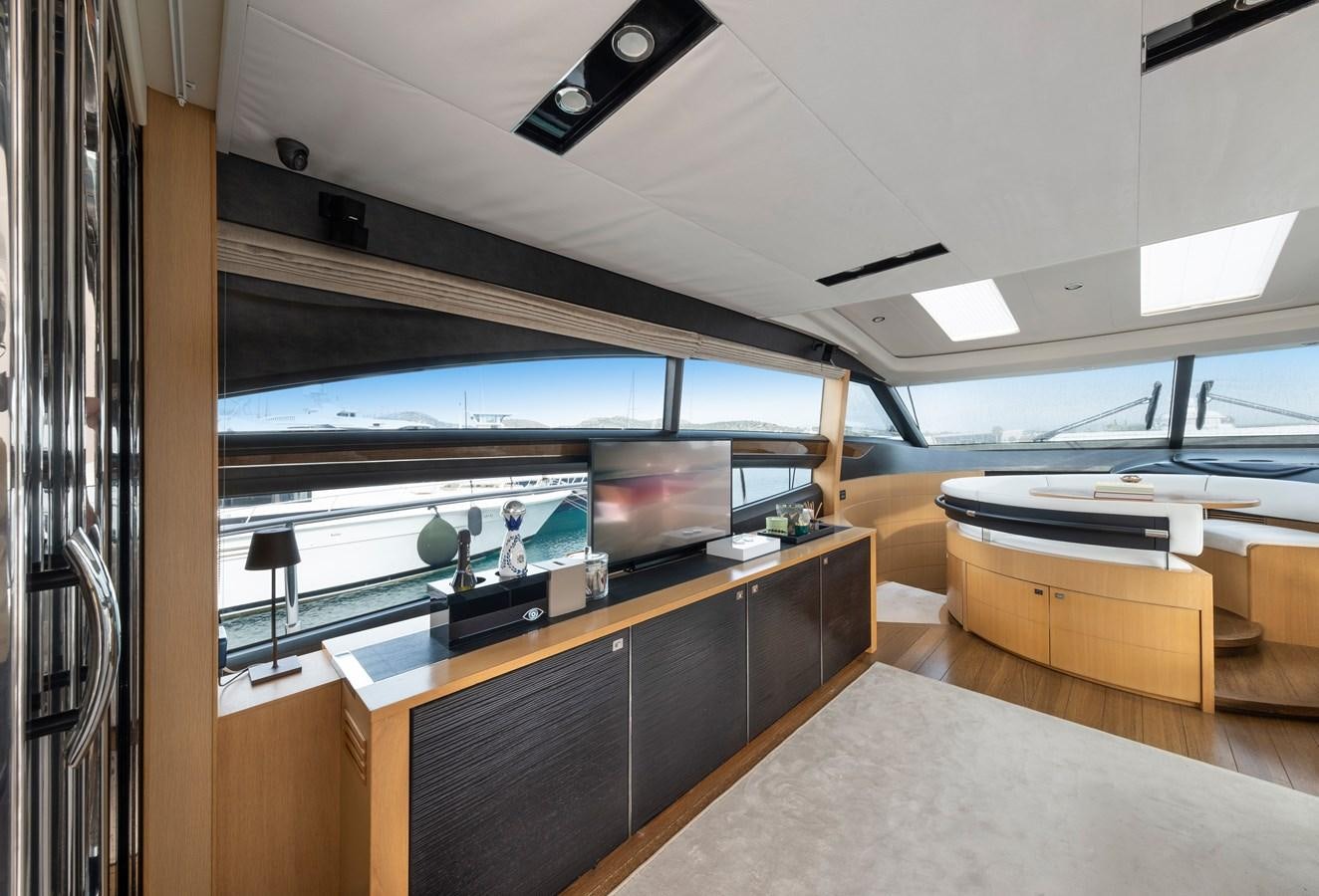 a room with a large tv and a table with chairs aboard WANDERER Yacht for Sale