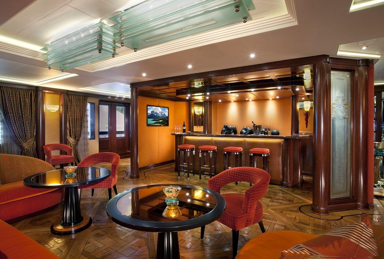 a room with a table chairs and a large window aboard ATTESSA IV Yacht for Sale