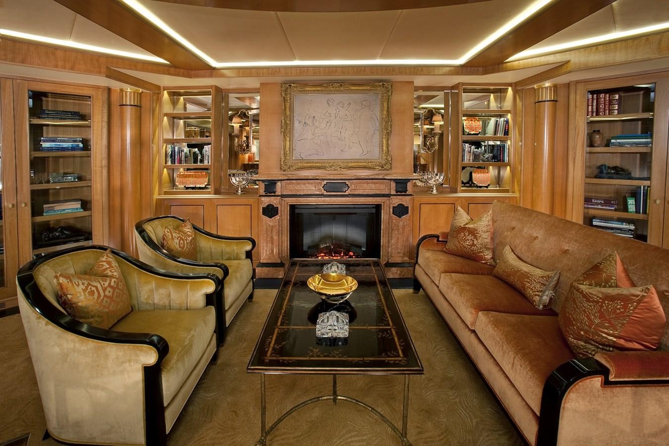 a living room with leather couches and a fireplace aboard ATTESSA IV Yacht for Sale