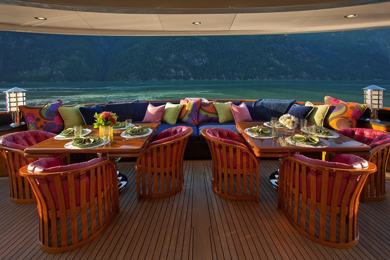 a deck with a table and chairs aboard ATTESSA IV Yacht for Sale