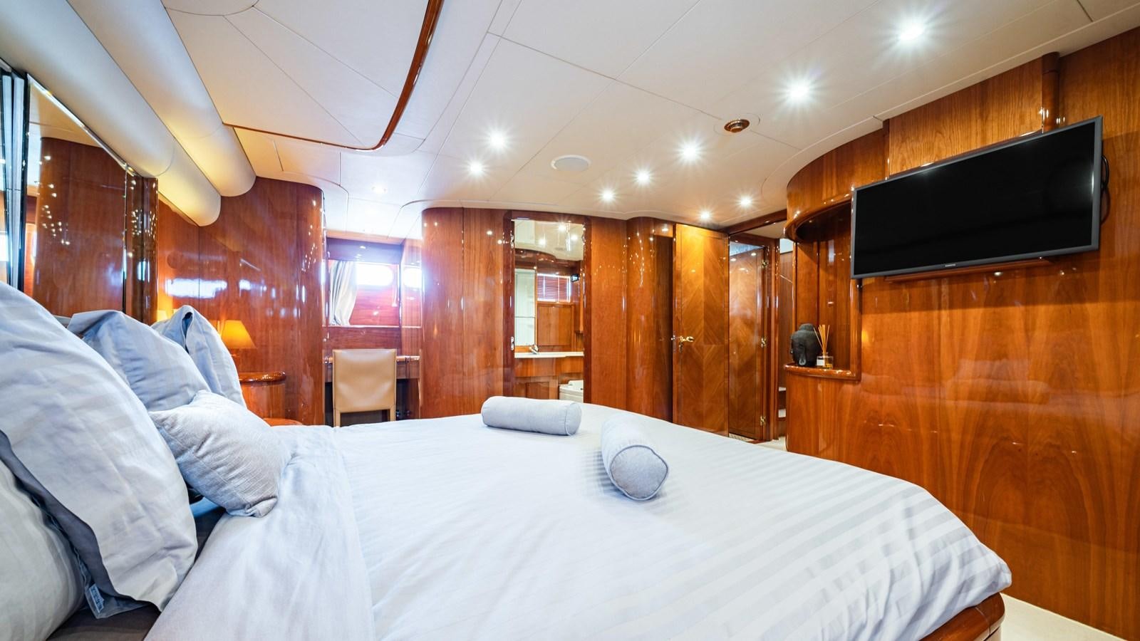 a bed with a white sheet and a television on it aboard BEIJA FLORE Yacht for Sale