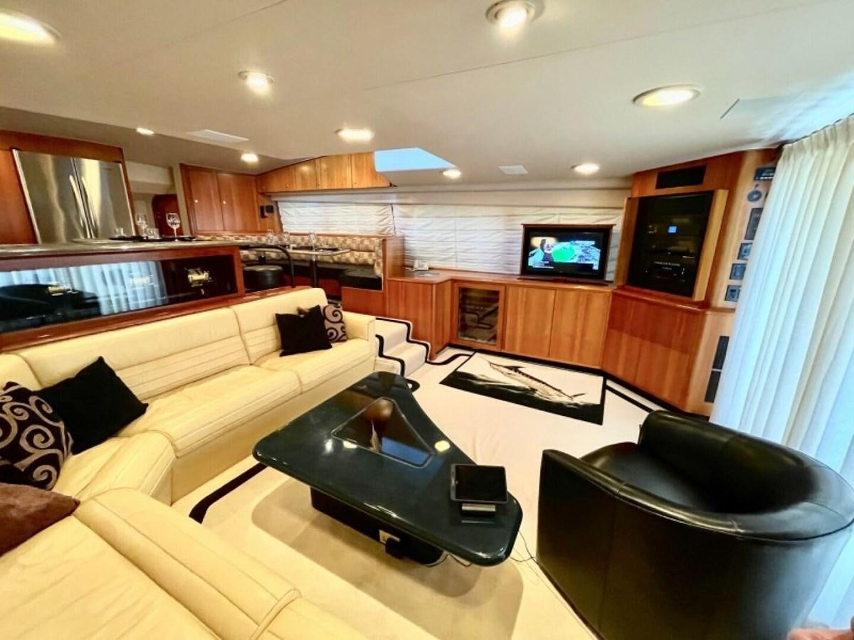 a living room with a tv and furniture aboard AFTER MIDNIGHT Yacht for Sale