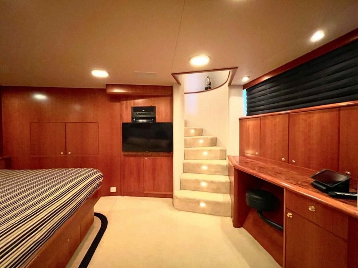 a room with a bed and a television aboard AFTER MIDNIGHT Yacht for Sale
