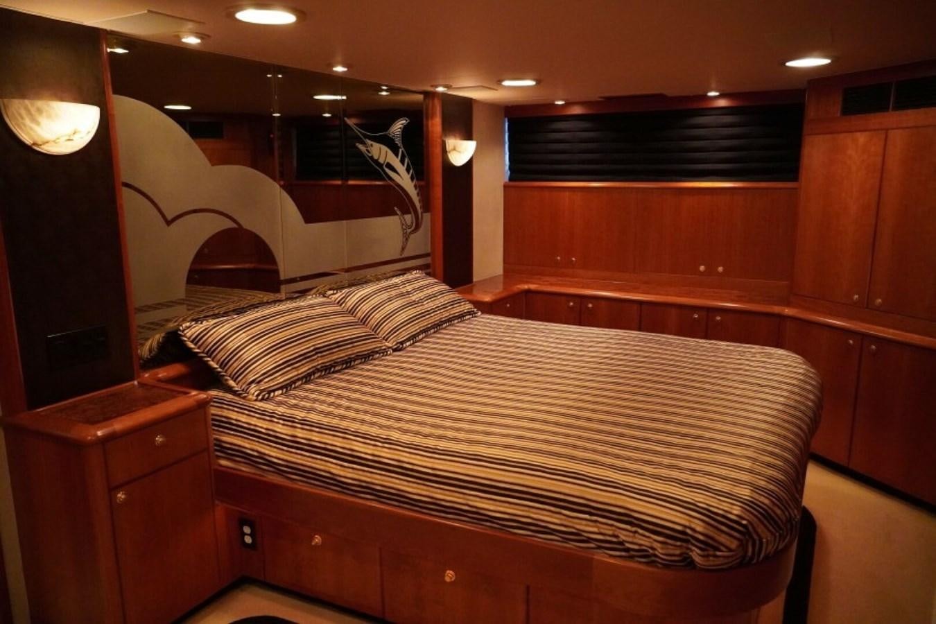 a bed with a wooden headboard aboard AFTER MIDNIGHT Yacht for Sale