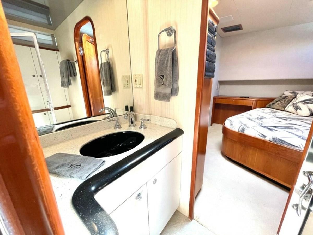 a bathroom with a sink and a bed aboard AFTER MIDNIGHT Yacht for Sale