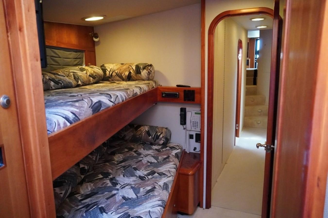 a room with a bed and a door aboard AFTER MIDNIGHT Yacht for Sale