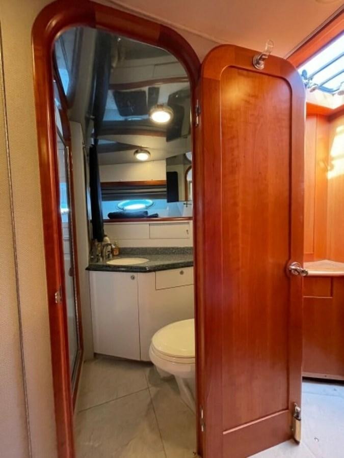 a bathroom with a toilet and a mirror aboard AFTER MIDNIGHT Yacht for Sale