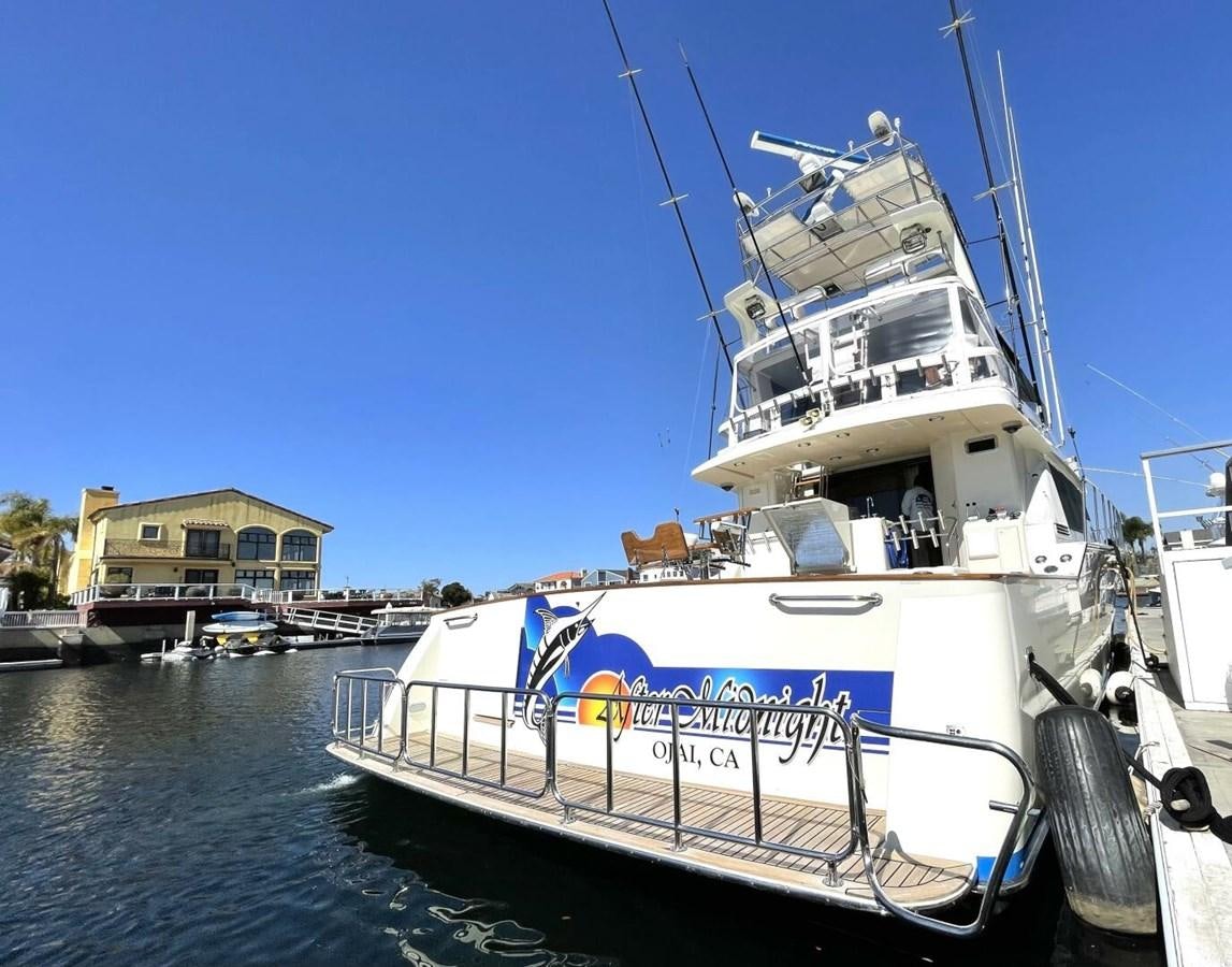 a large white boat in a harbor aboard AFTER MIDNIGHT Yacht for Sale