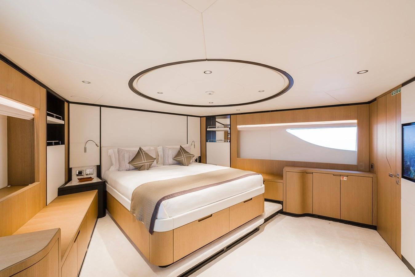 a room with a bed and a round mirror aboard MAJESTY 111 Yacht for Sale