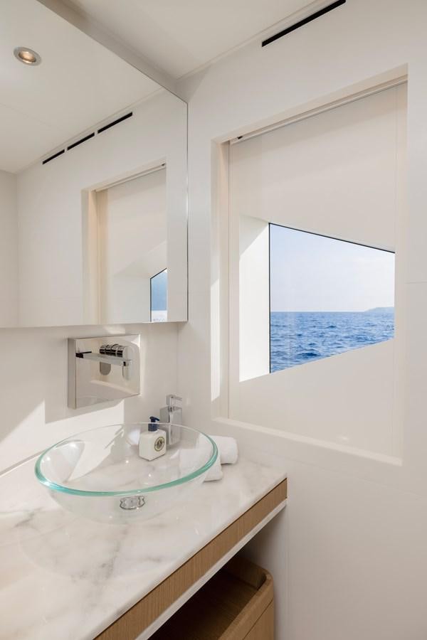 a bathroom with a sink and a window aboard MAJESTY 111 Yacht for Sale