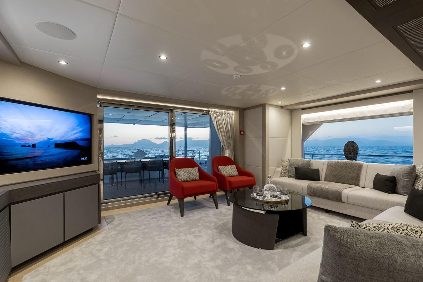 a living room with a large window aboard NOMAD 95 SUV Yacht for Sale