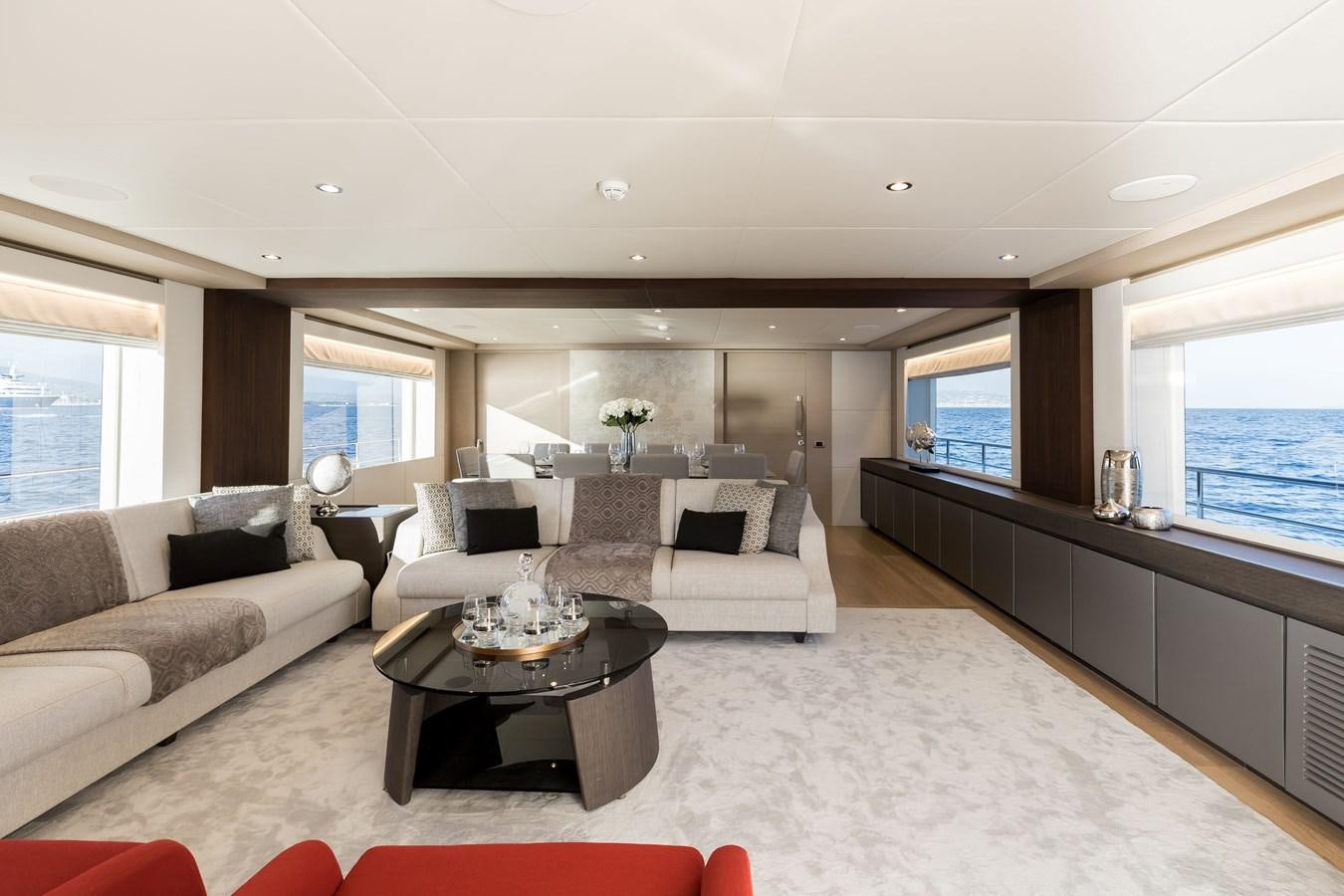 a living room with a white couch and a coffee table aboard NOMAD 95 SUV Yacht for Sale