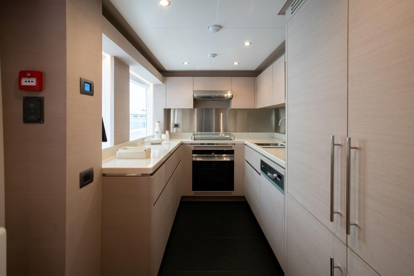a kitchen with white cabinets aboard NOMAD 95 SUV Yacht for Sale