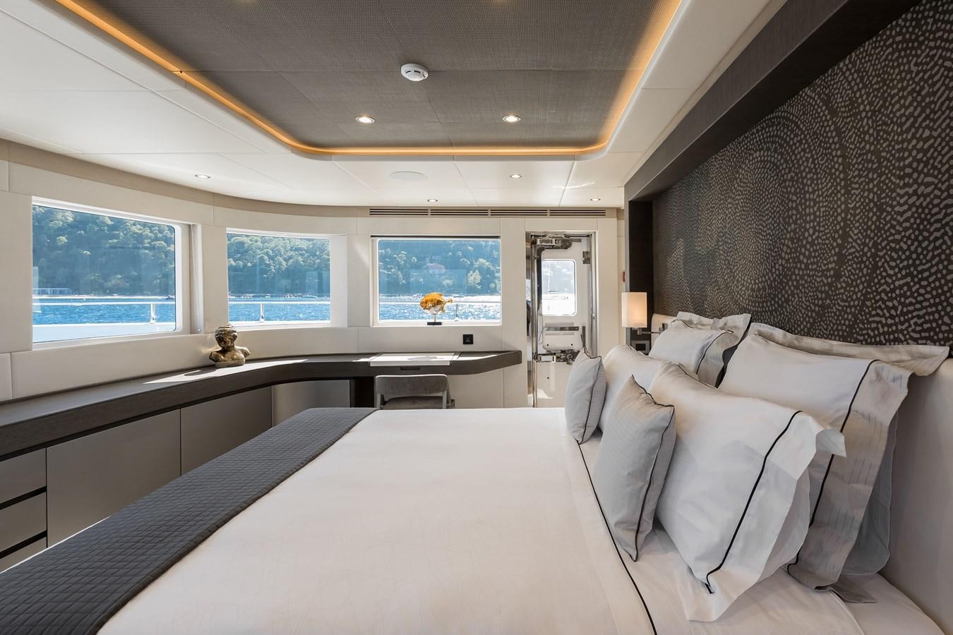 a room with a bed and a desk aboard NOMAD 95 SUV Yacht for Sale