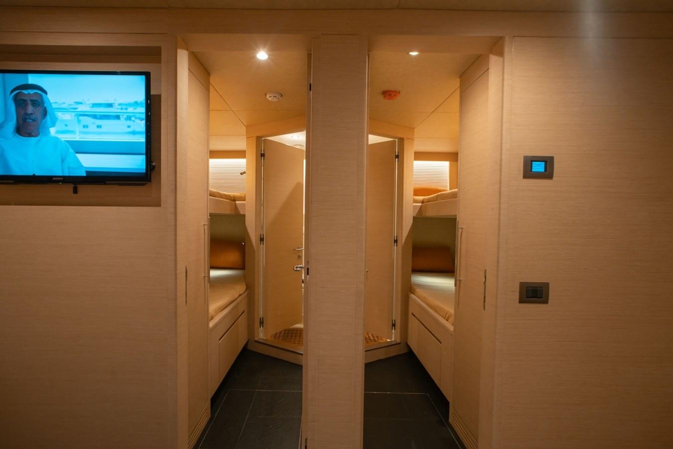 a room with a tv on the wall aboard NOMAD 95 SUV Yacht for Sale
