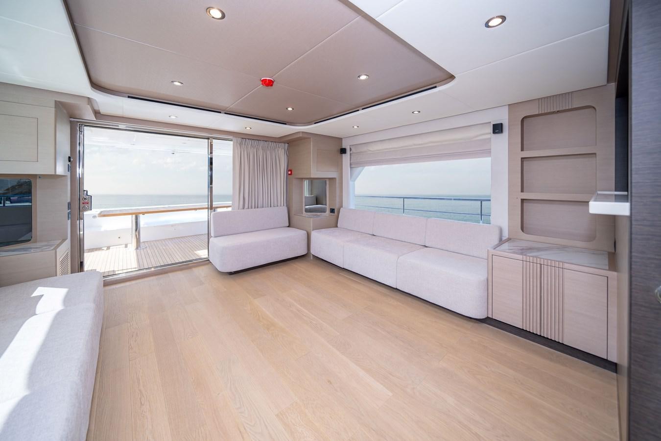a living room with a large window aboard #4 NOMAD 75 SUV Yacht for Sale