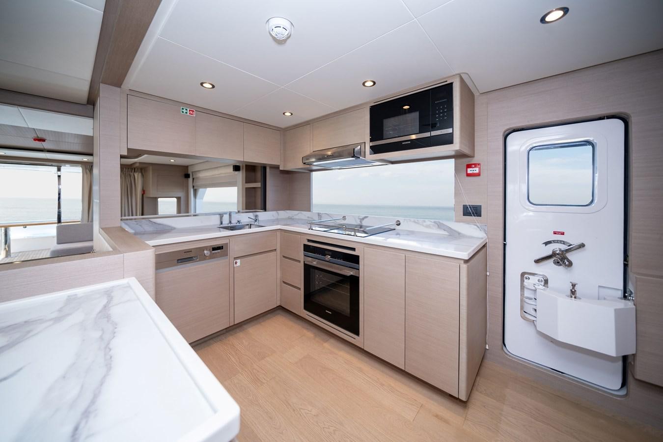 a kitchen with a microwave oven and a sink aboard #4 NOMAD 75 SUV Yacht for Sale