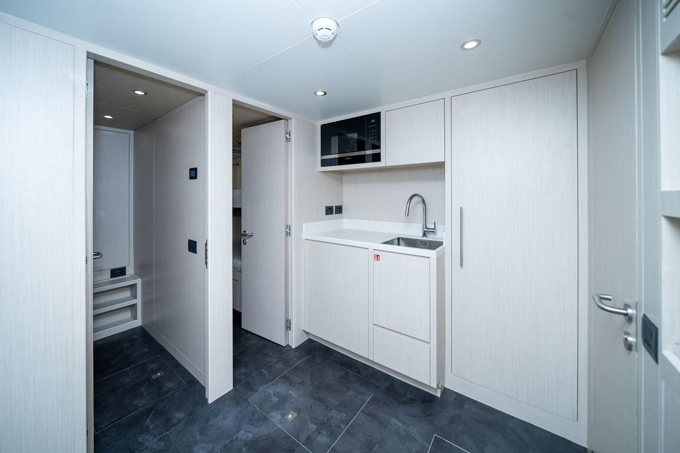 a kitchen with white cabinets aboard #4 NOMAD 75 SUV Yacht for Sale
