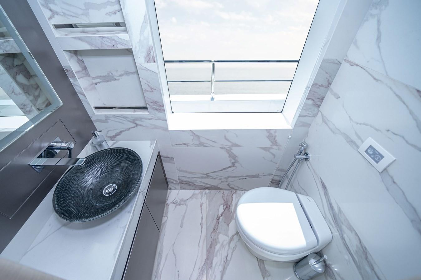 a small bathroom with a sink and toilet aboard #4 NOMAD 75 SUV Yacht for Sale