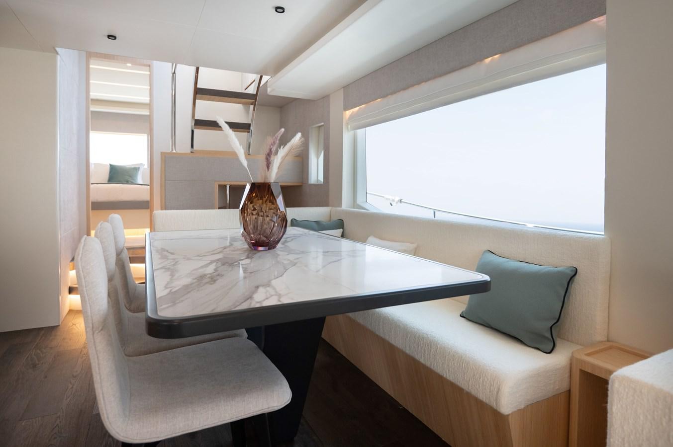 a living room with a table and chairs aboard NOMAD 70 SUV Yacht for Sale