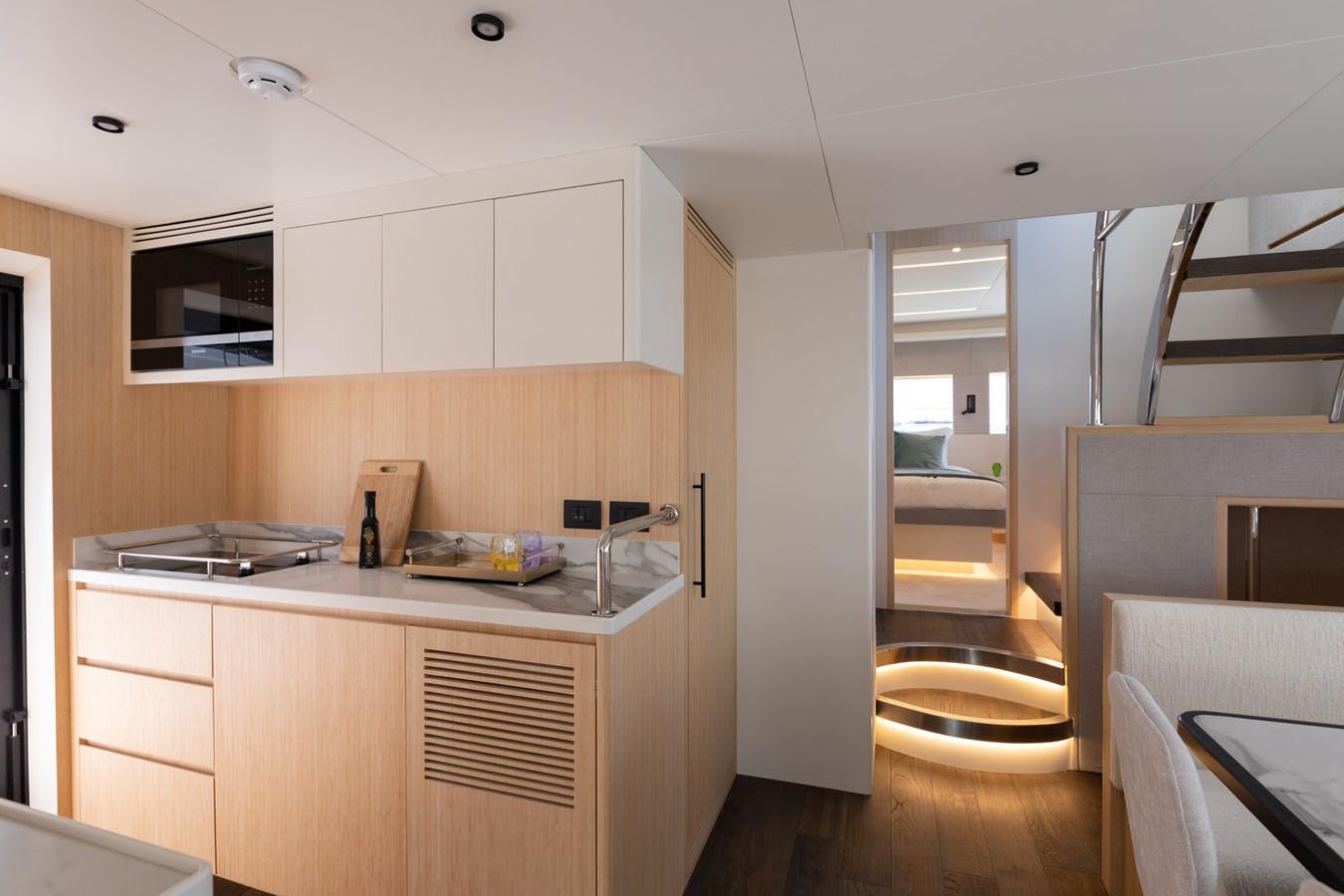 a kitchen with white cabinets aboard NOMAD 70 SUV Yacht for Sale