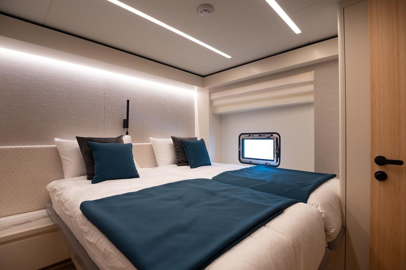 a bed with blue sheets aboard NOMAD 70 SUV Yacht for Sale