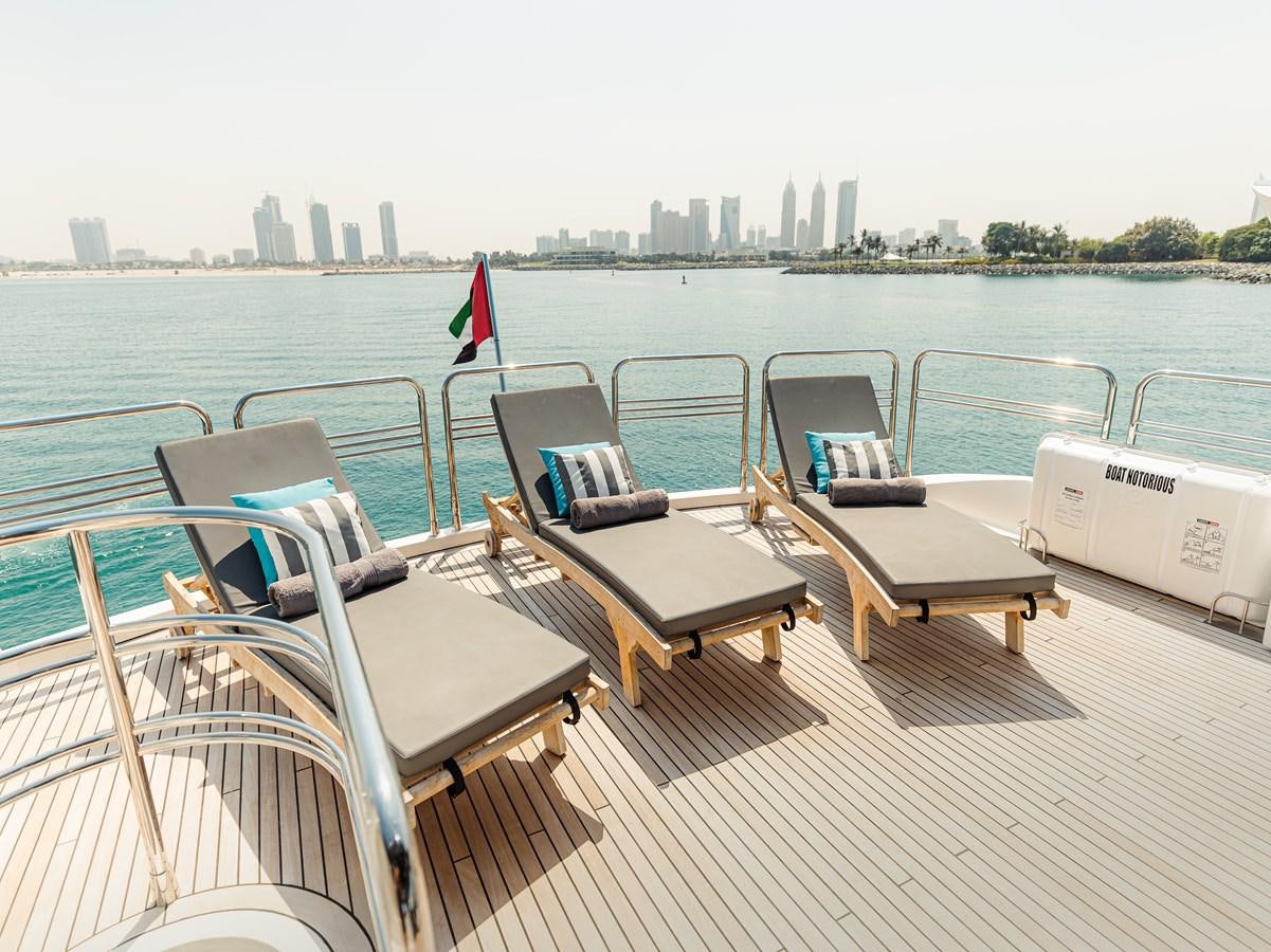 a deck with chairs and a table on it aboard AARNA Yacht for Sale