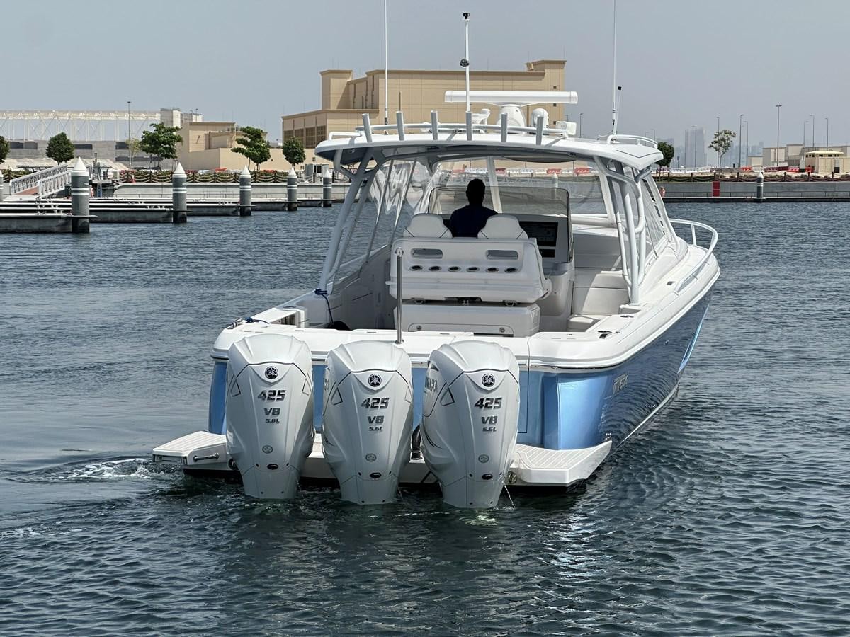 a person driving a boat aboard 2023 INTREPID 41 VALOR Yacht for Sale